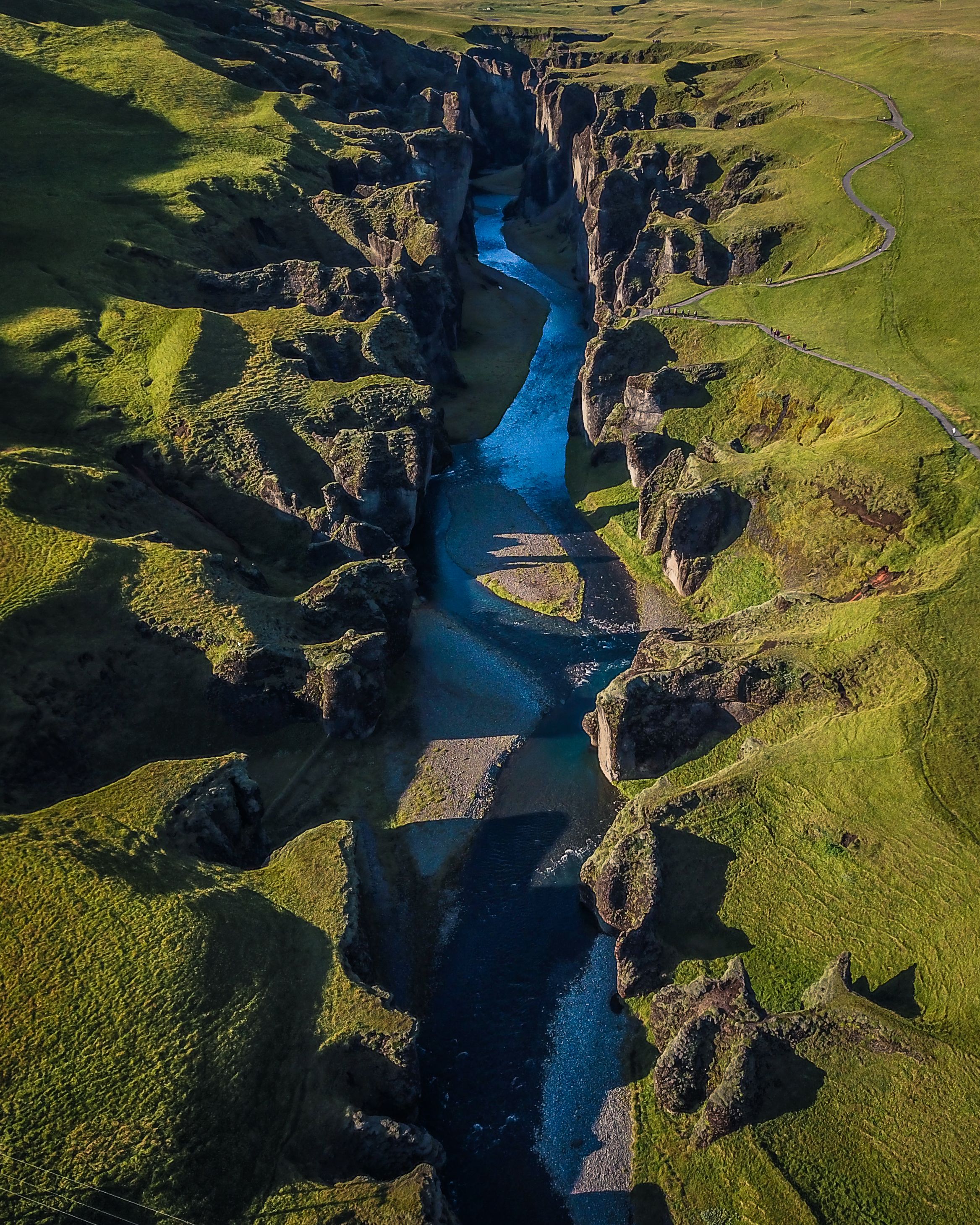 A blue river winding through a green canyon