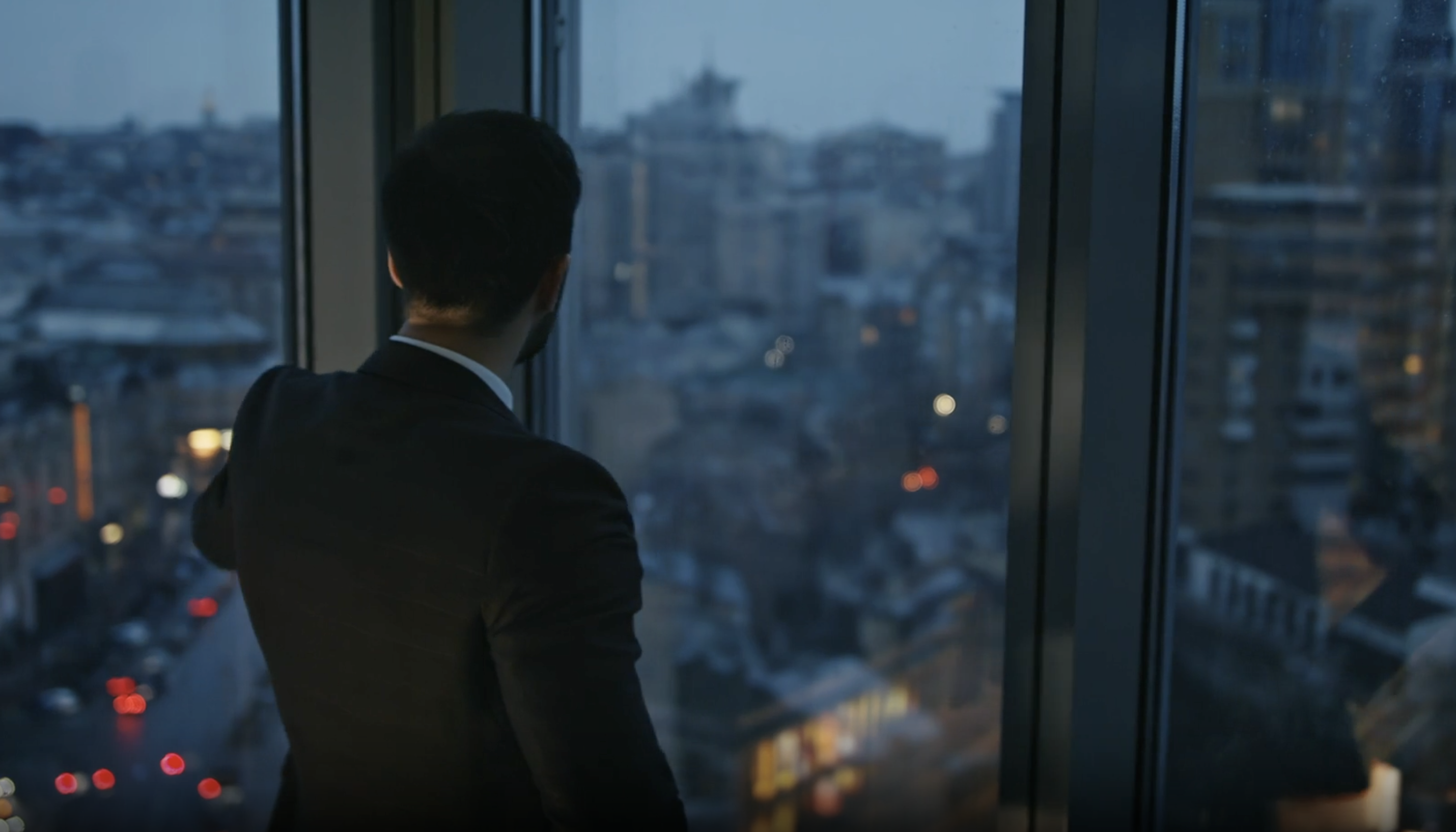 A man looking out over the city at dusk