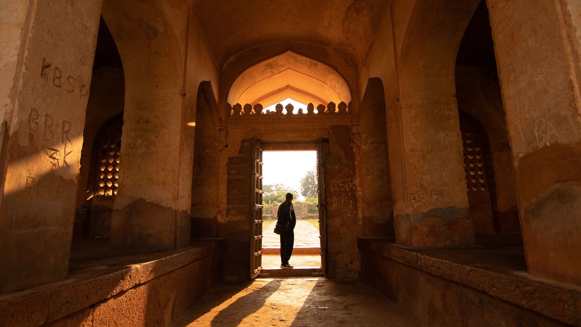 A traveller walking through a doorway into the light